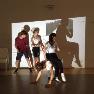 A group of young people try to fit the outlines of projected images.