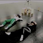 A couple of people laying on the ground with VR headsets on.
