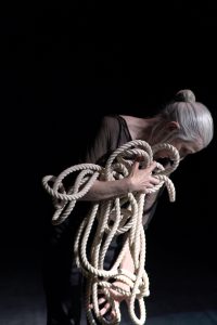 An woman holding on to several pieces of rope in their hands