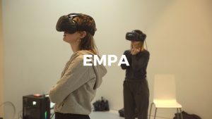 Two women wearing virtual headsets in a room.