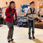 Two young people are wearing motion capture suits at a youth centre.